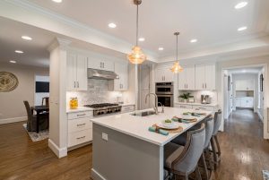 Gourmet white kitchen with professional grade appliances. Flows to dining room and hallway leading to laundry room. 4200 Chelsmford. Bullard Realty Group
