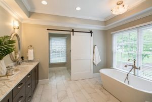 4200 Chelmsford Lane Master bath with marble countertops, grey soft close cabinetry and free-standing garden tub, sliding door leading to shower room